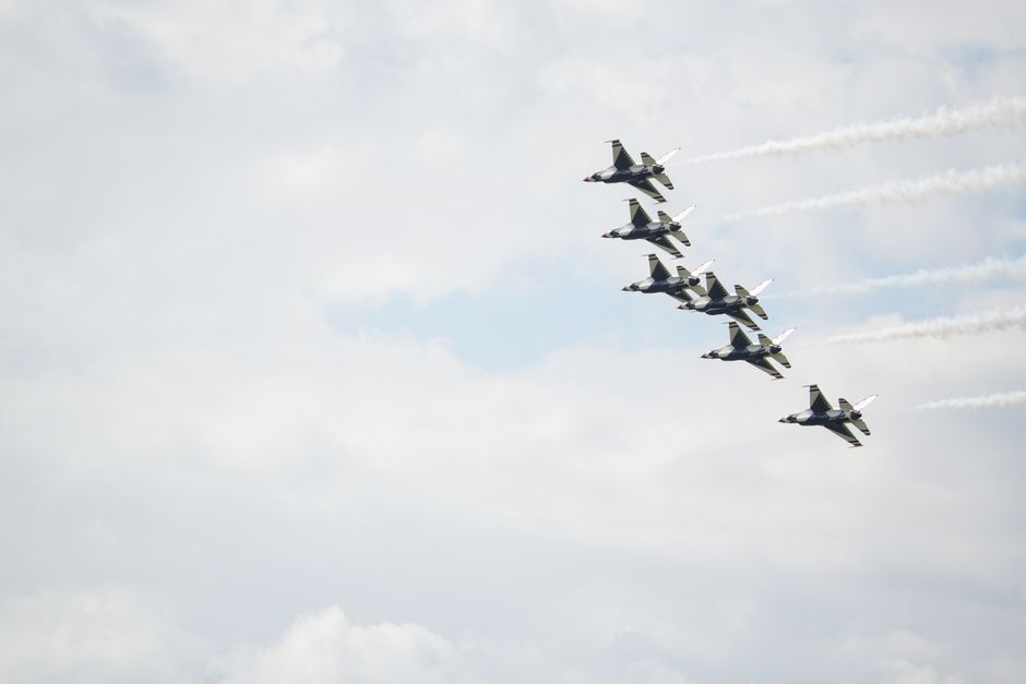 A formation of US Air Force F-16 fighter jets soaring through a cloudy sky during an air show.