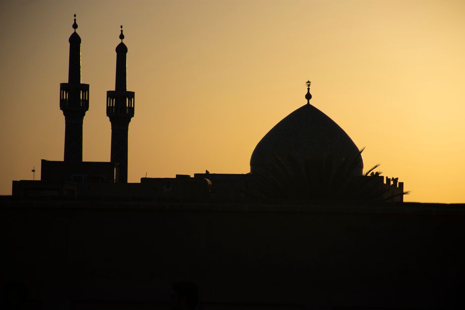 A stunning silhouette of a mosque's minarets and dome at sunset, capturing the essence of Yazd, Iran.