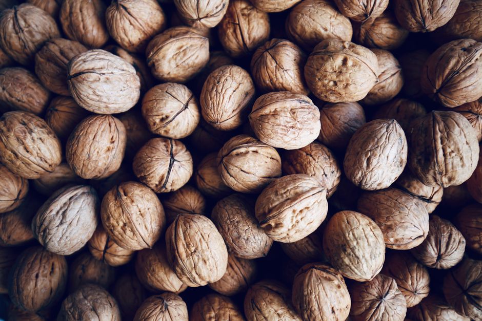 A high-quality close-up image of numerous walnuts in shells, perfect for healthy eating concepts.