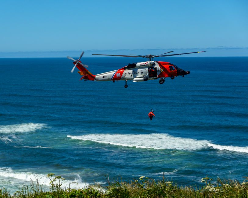 Dramatic coast guard helicopter rescue operation over the ocean waves.